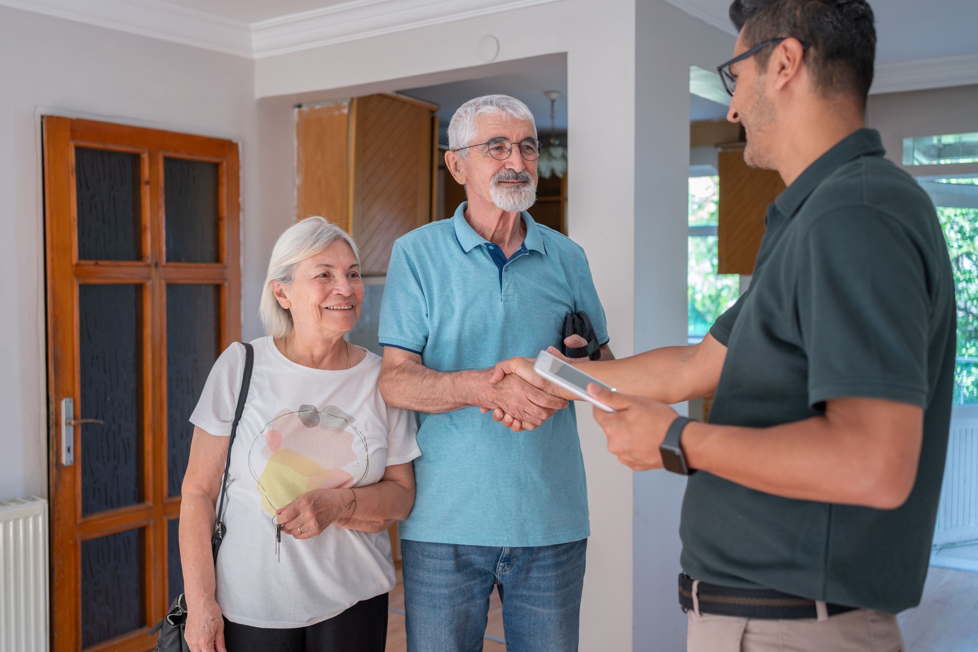 Senior Couple Handshake With Real Estate Agent At Home